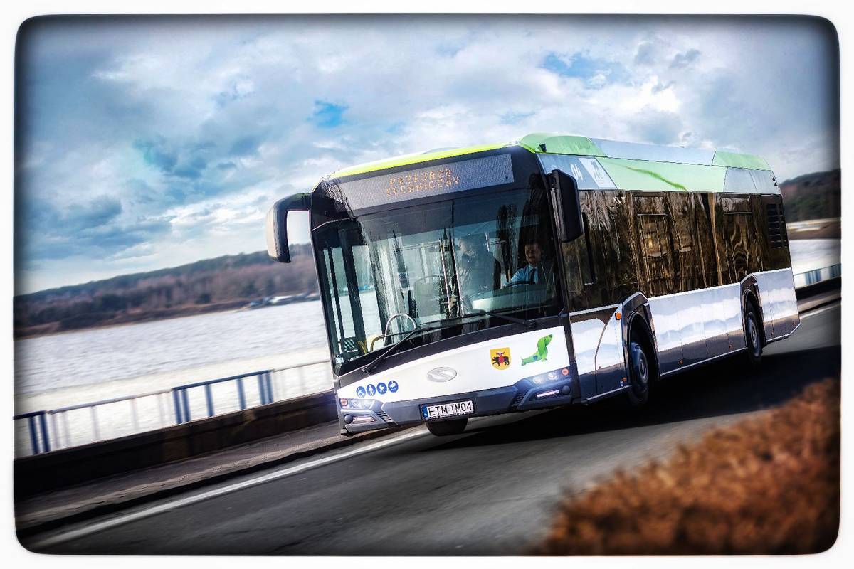 Na zdjęciu autobus MZK przejeżdżający przez tamę Zalewu Sulejowskiego, widać zbiornik wodny w tle oraz las