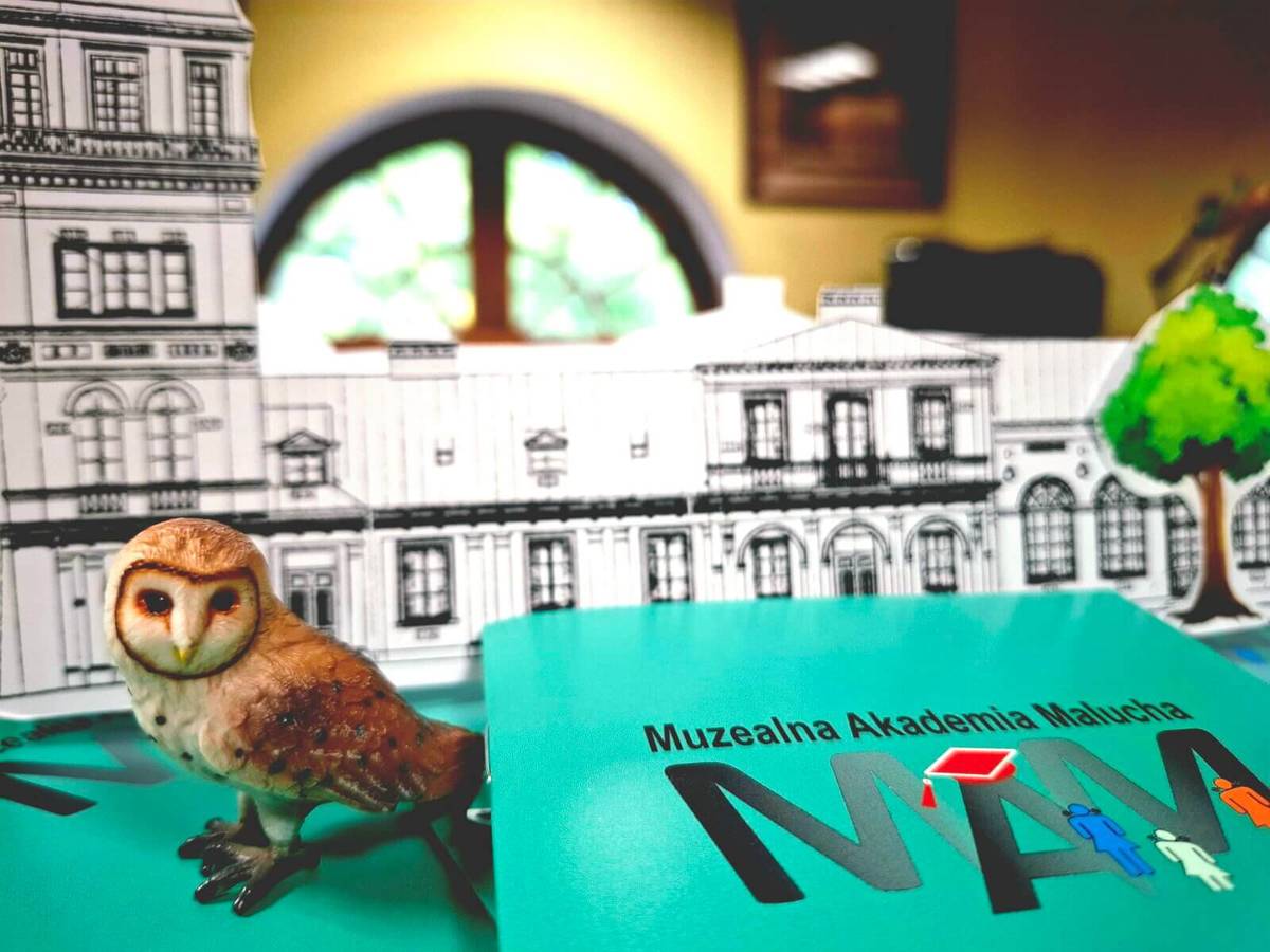Na zdjęciu baner Młodzieżowej Akademii Malucha w Muzeum. Na banerze logo Akademii z ptakiem sową na pierwszym planie