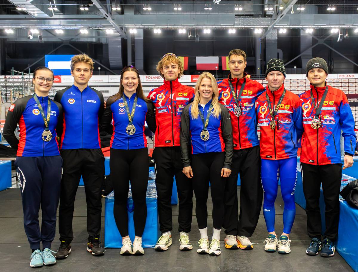 Na zdjęciu zawodnicy i zawodniczki KS Pilica z medalami Mistrzostw Polski na Dystansach pozują do wspólnego zdjęcia z medalami i w strojach klubowych na Arenie Lodowej