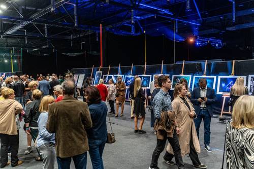 Uczestnicy koncertu, oglądający fotografie i plakaty jazzowe