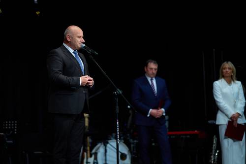 Przemówienie okolicznościowe Prezydenta Miasta Tomaszowa Mazowieckiego z okazji Dnia Edukacji Narodowej. Prezydent przemawia ze sceny, w tle stoi starosta powiatu