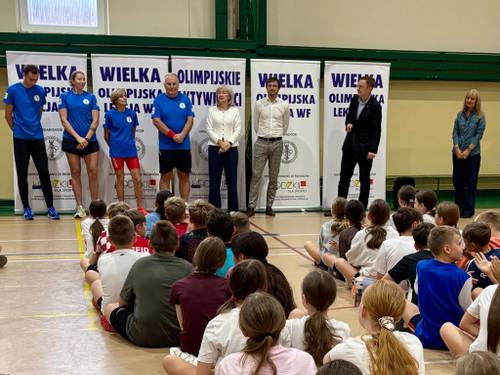 Na zdjęciu Olimpijczycy na lekcji WF spotykają się z uczniami Szkoły Podstawowej nr 6 na sali gimnastycznej. Uczniowie w strojach gimnastycznych