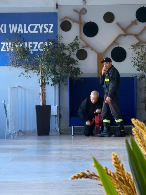 Strażacy przy pomocy ręcznej syreny odtwarzają sygnał alarmowy